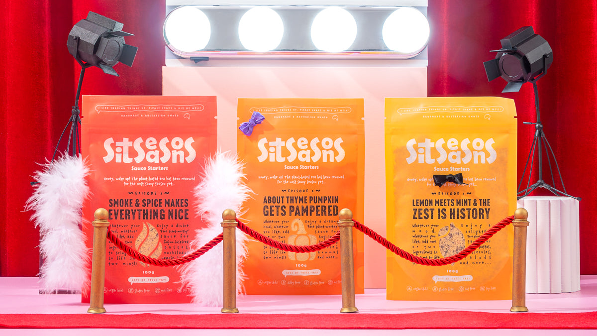 Vegan sauce packets standing in front of a 'season of sauce' spotlight on red carpet
