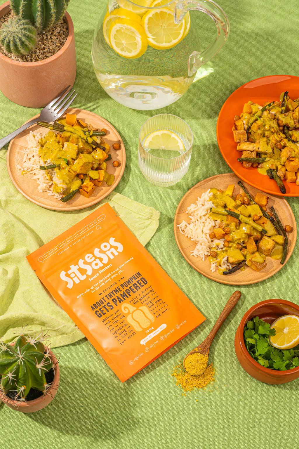 Three plates of vegan pumpkin curry with an orange sauce packet