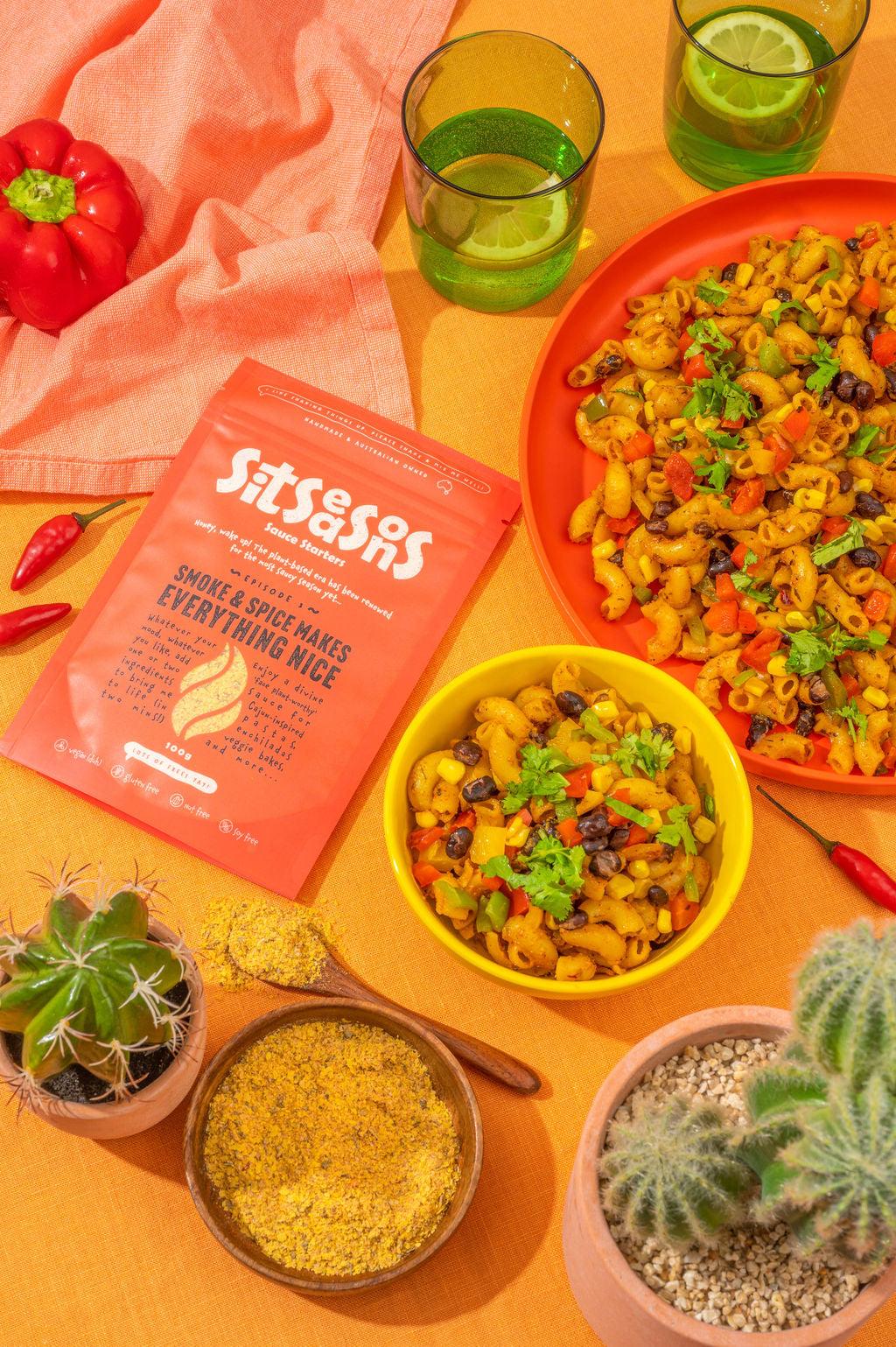 A bowl and plate of vegan smoky spicy pasta with a red sauce packet