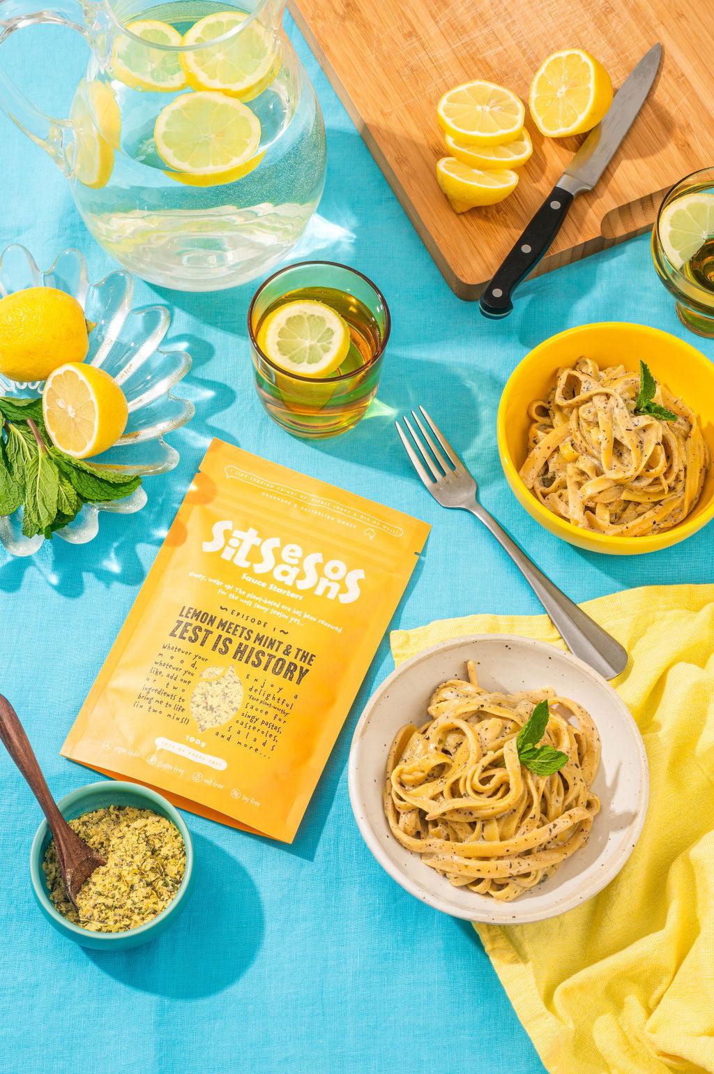 Two bowls of vegan lemon pasta with a yellow sauce packet