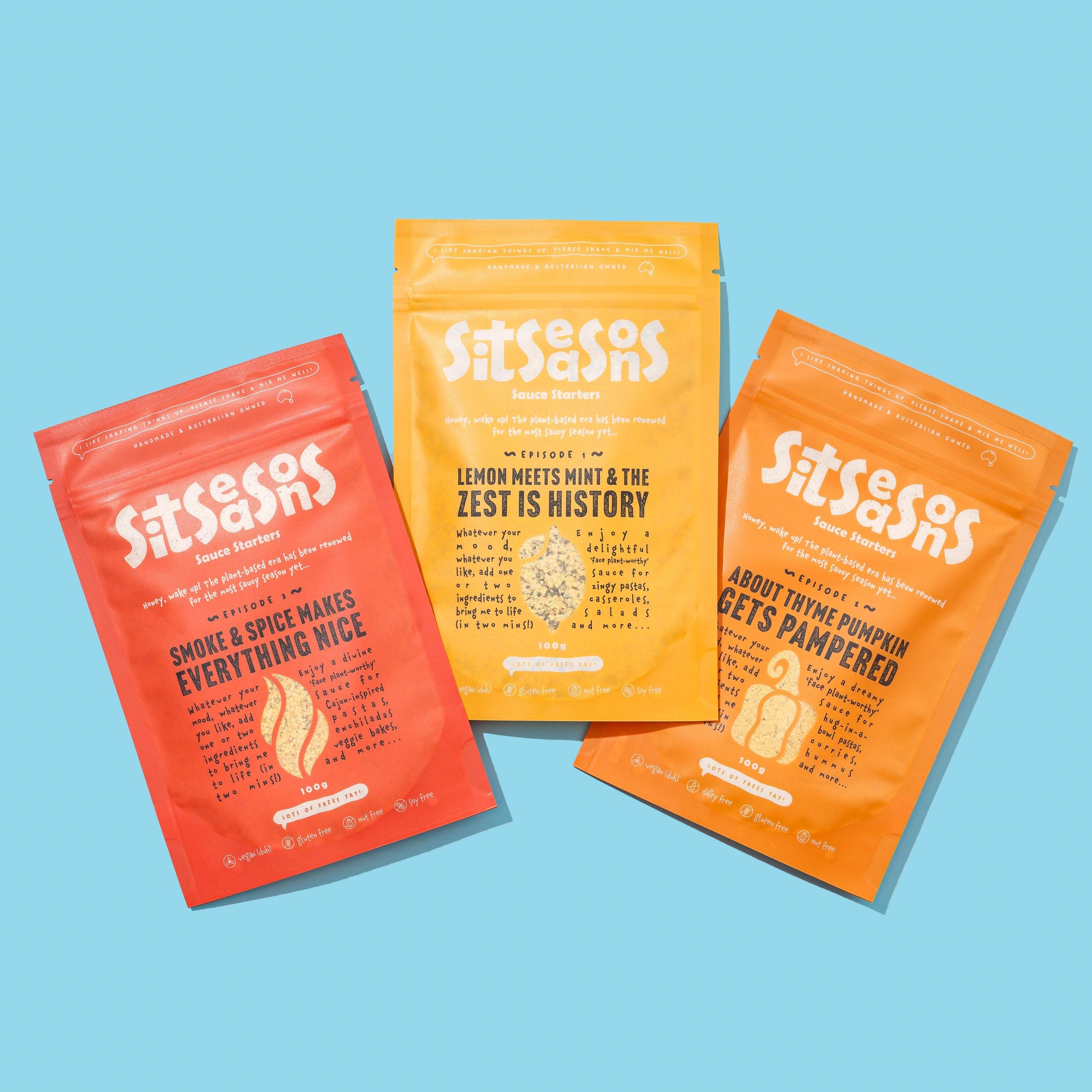 Three 100g multicoloured packets of lemon, pumpkin and smoky spicy vegan sauces
