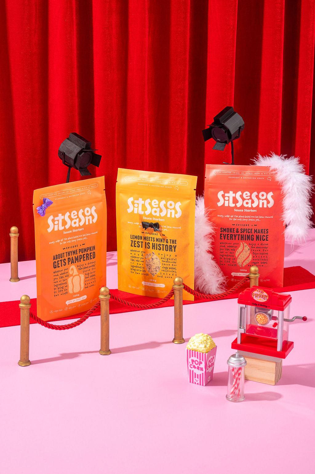 Vegan sauce packets posing on a red carpet with surrounding gold bollards